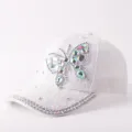 Détail de la casquette en dentelle blanche avec papillon en strass iridescents brillants. - Réglable / Style Papillon en Strass Dentelle / Blanc