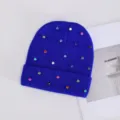 Primer plano detalle del gorro de punto azul real decorado con pedrería de colores. - Strass de Colores Clavo Redondo / Azul Zafiro