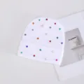 Primer plano detallado de un gorro de punto blanco decorado con diamantes de imitación. - Strass de Colores Clavo Redondo / Blanco