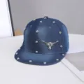 Vista detallada de gorra de béisbol de mezclilla con tachuelas metálicas y parche de toro. - Ajustable / Motivo de Cuerno de Buey / Azul Denim