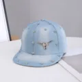Vista detallada de gorra de béisbol de mezclilla azul claro con calavera de toro y remaches. - Ajustable / Motivo de Cuerno de Buey / Azul claro