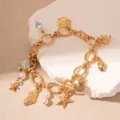 Detailed view of ocean style golden charm bracelet with pearls and starfish charms - Drip Oil Ocean Multi-Charm (Light Blue) / Gold
