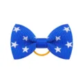 Vista dettagliata di un fiocco per capelli blu con stelle bianche ed elastico arancione vivo. - Stile 16