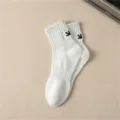 Men's white combed cotton mid-tube sports socks with black embroidered arrow detail. - One Size / White