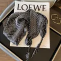 Detailed shot of a black and white patterned triangular scarf with cute tassels. - Geometric Blue / Wheat Black