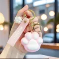 Detailed view of a cute pink silicone cat paw keychain with a Lucky Day wrist strap - Pink