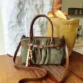 Dettaglio borsa a spalla in camoscio verde rétro, borsa casual con ciondolo di perline. - Verde con Pendente