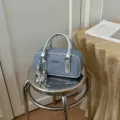 Detailansicht der modischen Jeans-Stepptasche mit schicken silbernen Metallgriffen. - Silber (Mit Anhänger)
