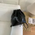 Black PU leather bucket backpack with motorcycle style zipper pocket, stylish commuter bag. - Black