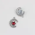 Detailed view of alloy moon and star pendant charms, featuring sparkling clear zircons and red crystal. - Silver / Red