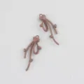 Dettaglio in primo piano di ciondolo fiocco cuore in lega marrone accessorio DIY. - Cachi