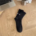 Black ribbed crew socks for men with embroidered cuff label and knit arch design. - One Size / Black