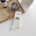 White ribbed crew socks featuring a camping lantern embroidery and comfortable combed cotton fabric. - One Size / Cream