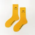 Chaussettes jaunes ornées d'un visage souriant et de lettres tricotées en coton doux. - Taille unique / Jaune