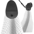 Detailed view of microfiber golf towel featuring a magnetic grey leather attachment strap - White