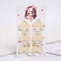 Close-up of 6 small pearl hair claw clips set presented on a cute cartoon display card - Bowknot Style (a17) / 6 Pieces/Pack (Small) / Pearl White