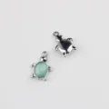 Close-up of cute turtle charm with light blue cabochon and silver metal pendant. - Silver Green