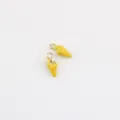 Gros plan sur le petit pendentif coquillage jaune, idéal pour la création de bijoux DIY. - Jaune