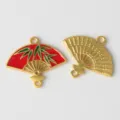 Nahaufnahme Detail eines goldenen Legierungsfächers mit rotem Email und grünem Bambus für Schmuck. - Rot