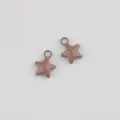 Detail close up view of painted alloy star charms for DIY handmade jewelry accessories. - Khaki