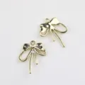 Detail shot of golden alloy bow charms, perfect jewelry accessories for DIY crafting. - Gold