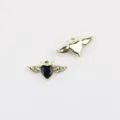 Nahaufnahme des Teufelsflügel-Herz-Anhängers, schwarze Zirkon-Einlage auf Goldlegierung. - Goldene Basis Schwarzer Strass