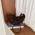 Vue détaillée d'un sac porté épaule imprimé léopard marron avec lanière nouée. - Léopard Café