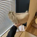 Vue detaillee du sac croissant tendance en daim kaki avec bandouliere nouee elegante. - Kaki