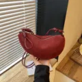 Détail de sac croissant en suédine rouge, sac épaule vintage avec poignée à nœud unique. - Rouge