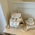 Vue détaillée du sac à dos beige pour femme avec joli pendentif d'ours, accessoire chic. - Avec Pendentif / Blanc Cassé