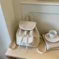 Vue détaillée du sac à dos en cuir beige pour femme avec rabat léopard et cordon de serrage. - Sans pendentif / Blanc Cassé