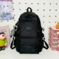 Dettaglio dello zaino nero con motivo a stelle, tasche multiple e design casual. - Con Ciondolo / Nero