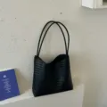 Close-up detail shot of the black woven leather shoulder tote bag, stylish and practical. - Black Leather