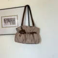 Vista dettagliata della chic borsa a spalla kaki arricciata con cinturini marroni e ciondolo. - Con Ciondolo / Kaki