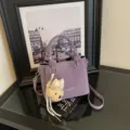 Bolso bombonera de cuero morado con colgante de peluche lazo, bolso cruzado elegante. - Con Colgante / Púrpura