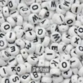 Closeup of white acrylic alphabet flat beads with clear black letters, size 7x4mm for DIY crafts. - White Black Letter