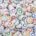 Close-up detail of white acrylic smiley face flat beads, perfect for DIY jewelry making crafts. - White with Colorful Letters Smiley