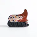 Vista lateral detallada de una pinza para el cabello vintage con forma de sombrero - Botas Marrones