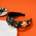 Detail view of Halloween knotted headband with gold foil star patterns on black fabric - Gold Pave Rhinestone Style / Black and Gold