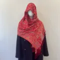 Detailed view of red paisley jacquard tassel shawl draped as an ethnic headscarf. - 70x180cm / Retro Copper