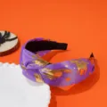 Detail of purple Halloween knotted headband with golden witch and star patterns - Purple Witch Style