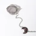 Stainless steel tea infuser ball with a natural rhodonite crescent moon crystal charm - Rhodonite