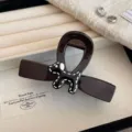 Close-up detail of the stylish dark brown hair claw clip featuring a cute black and white dog decor. - Black Dog Hair Claw