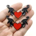 Close-up detail van gotische duivel hart vleugels metalen bedels, rood zwarte legering. - Rood Hart Zwarte Vleugels