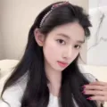 Vista dettagliata di un elegante cerchietto con perle e fiocco, accessorio per capelli. - Rosa