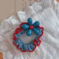 Blue floral hair scrunchie detail shot, cute blue and red fabric hair accessory close up - Light Blue Denim