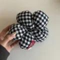 Detailed view of a black and white gingham floral hair scrunchie, showcasing fabric texture. - Black White Grid