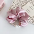 Elegant pink satin scrunchie with faux pearls and metal button accent, stylish hair accessory. - Pink Satin Pearl Hair Ring