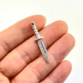 Close-up detail of a vintage mini alloy dagger charm pendant for DIY crafts and jewelry making. - Antique Silver
