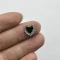 Close-up detail shot of a retro gothic black heart nail art charm with silver rays. - Radiant Heart